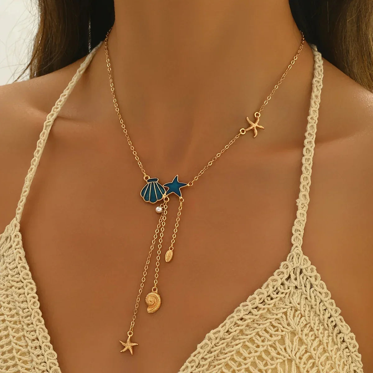 Elegante goldene Halskette mit Stern und blauer Muschel" could be rewritten as: "Stilvolle goldene Halskette mit Sternanhänger und blauer Muschel